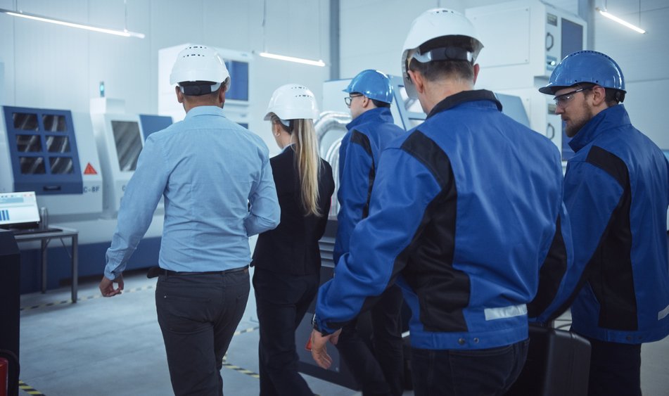 Un groupe de travail effectue une visite pour auditer une usine qui travaille de l'acier